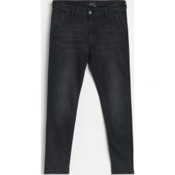 Jeansowe chinosy slim - Czarny. Czarne spodnie męskie Reserved, bez wzorów, z jeansu. Za 129,99 zł.