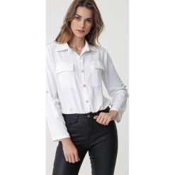 Biała Koszula Tingara. Białe bluzki damskie Born2be, m, bez wzorów, eleganckie, bez kołnierzyka, bez rękawów. Za 109,99 zł.