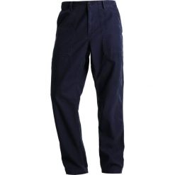 Chinosy męskie: Carhartt WIP FATIGUE SANDERS Spodnie materiałowe dark navy stone washed