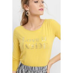 Koszulka z metalicznym napisem. Żółte t-shirty damskie Orsay, s, z napisami, z elastanu, z długim rękawem. W wyprzedaży za 30,00 zł.