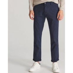 Bawełniane spodnie slim fit - Granatowy. Niebieskie spodnie męskie Reserved, m, bez wzorów, z bawełny. Za 149,99 zł.
