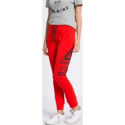 Reebok - Spodnie. Czerwone spodnie damskie Reebok, s, z nadrukiem, z bawełny. W wyprzedaży za 139,90 zł.