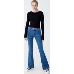 Spodnie dzwony ze średnim stanem. Niebieskie spodnie damskie Pull&Bear, z jeansu. Za 79,90 zł.