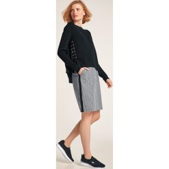 Sweter w kolorze czarnym. Czarne swetry damskie Heine, bez wzorów, bez rękawów, bez kaptura. W wyprzedaży za 129,95 zł.