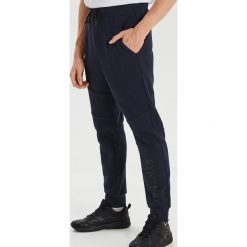 Dresowe joggery z nadrukiem - Granatowy. Niebieskie spodnie męskie Cropp, s, z nadrukiem, z dresówki. Za 119,99 zł.