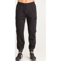 SPODNIE Armani Exchange. Czarne spodnie męskie Armani Exchange, na imprezę, m, z aplikacjami, z materiału. Za 419,40 zł.