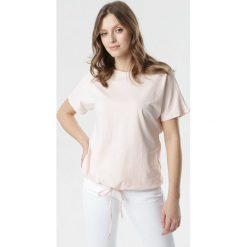 Jasnoróżowy T-shirt Malinore. Różowe bluzki damskie Born2be, s, bez wzorów, z okrągłym kołnierzem, z krótkim rękawem. Za 54,99 zł.