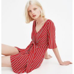 Kopertowa sukienka z węzłem. Czerwone sukienki damskie z falbanami marki Pull&Bear, z kopertowym dekoltem, kopertowe. Za 79,90 zł.