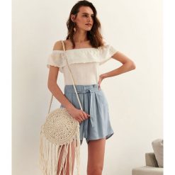 Bluzka damska z haftowaną falbanką. Białe bluzki damskie Top Secret, z haftami, eleganckie, z falbankami, bez rękawów. W wyprzedaży za 34,99 zł.