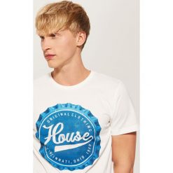 T-shirt z nadrukiem Kremowy. Białe t-shirty męskie House, s, z nadrukiem, bez kołnierzyka. W wyprzedaży za 19,99 zł.