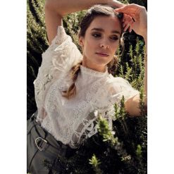 Biała Bluzka Grecia. Białe bluzki damskie Born2be, s, w koronkowe wzory, z koronki, ze stójką, z krótkim rękawem. Za 89,99 zł.