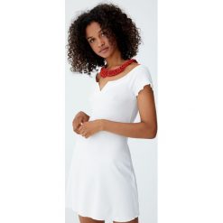 Prążkowana sukienka mini z dekoltem łódką. Białe sukienki damskie dzianinowe marki Pull&Bear, z dekoltem w łódkę, mini. Za 69,90 zł.