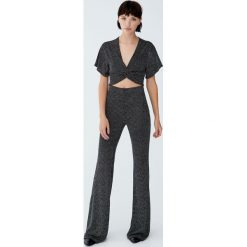 Metaliczne spodnie dzwony. Czarne spodnie damskie Pull&Bear. Za 99,90 zł.