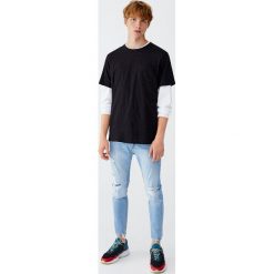 Jeansy carrot fit premium z efektem zużycia. Niebieskie jeansy męskie marki Pull&Bear, m, bez wzorów. Za 139,00 zł.