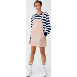 Różowa sztruksowa sukienka ogrodniczka. Różowe sukienki damskie Pull&Bear, bez wzorów, ze sztruksu, bez kołnierzyka, bez rękawów. Za 99,90 zł.