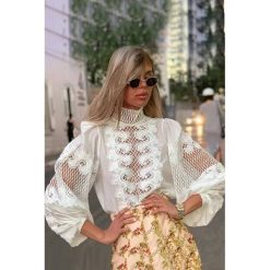 Damska bluzka SAZA WHITE. Białe bluzki damskie IVET, z aplikacjami, z materiału, eleganckie, bez kołnierzyka, z długim rękawem. W wyprzedaży za 99,00 zł.