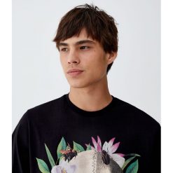 Koszulka z czaszką i tropikalnymi liśćmi. Białe koszulki męskie Pull&Bear, m, bez wzorów, bez kołnierzyka, z krótkim rękawem, krótkie. Za 49,90 zł.