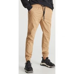 Spodnie jogger slim fit - Beżowy. Brązowe spodnie męskie marki Reserved, m, bez wzorów. Za 129,99 zł.