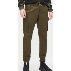 Joggery cargo - Khaki. Brązowe spodnie męskie Cropp, m. Za 129,99 zł.
