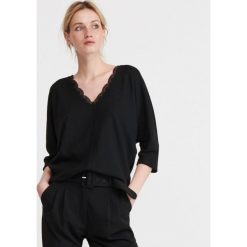 Dzianinowa bluzka z koronką - Czarny. Czarne bluzki damskie Reserved, s, w koronkowe wzory, z dzianiny, bez kołnierzyka, bez rękawów. Za 79,99 zł.