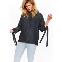 Bluzka elegancka damska z połyskującej tkaniny. Czarne bluzki damskie Top Secret, bez wzorów, z jeansu, eleganckie, bez kołnierzyka, bez rękawów. W wyprzedaży za 39,99 zł.