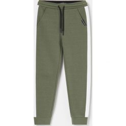 Joggery z kontrastowymi lampasami - Khaki. Brązowe spodnie męskie Reserved, bez wzorów. Za 45,99 zł.