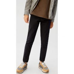 Mango Kids - Spodnie dziecięce Calum 110-164 cm. Czarne spodnie chłopięce Mango Kids, bez wzorów, z elastanu. W wyprzedaży za 59,90 zł.
