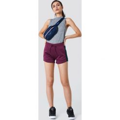 NA-KD Szorty sportowe - Purple. Fioletowe spodenki sportowe damskie marki NA-KD, z poliesteru, sportowe. W wyprzedaży za 24,28 zł.