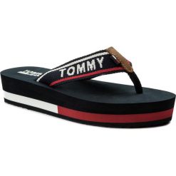 Japonki TOMMY JEANS - Mid Beach Sandal EN0EN00069 Tommy Navy 406. Niebieskie klapki damskie marki Tommy Jeans, bez wzorów, z jeansu, bez obcasa, na koturnie. W wyprzedaży za 129,00 zł.
