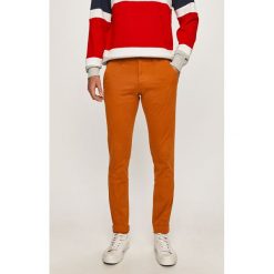 Tommy Jeans - Spodnie. Pomarańczowe spodnie męskie Tommy Jeans, bez wzorów, z elastanu. Za 399,90 zł.