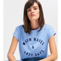 T-shirt z błyszczącym napisem - Niebieski. Niebieskie t-shirty damskie Reserved, s, z napisami, bez kołnierzyka. Za 29,99 zł.