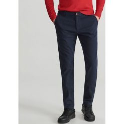 Dopasowe spodnie chino - Granatowy. Niebieskie chinosy męskie marki Reserved, m. Za 129,99 zł.