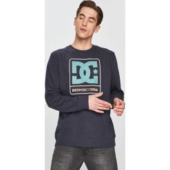 DC - Bluza. Niebieskie bluzy męskie DC, s, z nadrukiem, z bawełny, z okrągłym kołnierzem, bez rękawów, bez kaptura. W wyprzedaży za 159,90 zł.