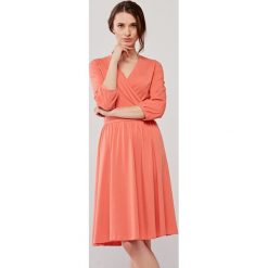 Sukienka Larissa brzoskwiniowa L różowy. Różowe sukienki damskie s, bez wzorów, z elastanu, bez kołnierzyka, bez rękawów, rozkloszowane. Za 297,00 zł.