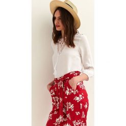 Luźna bluzka z koronką. Białe bluzki damskie Top Secret, w koronkowe wzory, z koronki, eleganckie, z dekoltem w serek, bez rękawów. Za 69,99 zł.