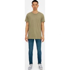 Ciemne jeansy skinny fit z efektem sprania i zużycia. Niebieskie rurki męskie marki Pull&Bear, z denimu. Za 119,00 zł.