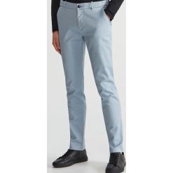 Bawełniane spodnie slim - Niebieski. Niebieskie spodnie męskie marki Reserved, m, bez wzorów, z bawełny. Za 129,99 zł.
