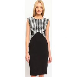 SUKIENKA DAMSKA WE WZORY. Czarne sukienki damskie marki Top Secret, na zimę, bez wzorów, z dzianiny, eleganckie, bez kołnierzyka, bez rękawów, dopasowane. W wyprzedaży za 59,99 zł.