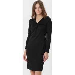 Czarna Sukienka Magali. Czarne sukienki damskie Born2be, na randkę, s, bez wzorów, bez kołnierzyka, z długim rękawem, długie, mini, dopasowane. Za 59,99 zł.