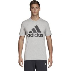 KOSZULKA MUST HAVES BADGE OF SPORT (M). Szare koszulki męskie Adidas, m, bez wzorów, z bawełny, z kontrastowym kołnierzykiem, bez rękawów, na fitness i siłownię. W wyprzedaży za 79,99 zł.