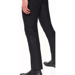 Spodnie eleganckie z lampasem. Czarne spodnie garniturowe męskie Top Secret, bez wzorów, eleganckie. W wyprzedaży za 79,99 zł.
