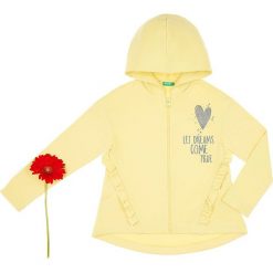 Bluza w kolorze żółtym. Żółte bluzy niemowlęce Benetton Kids, z nadrukiem, z bawełny, bez rękawów, bez kaptura. W wyprzedaży za 42,95 zł.