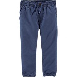 Spodnie w kolorze niebieskim. Niebieskie spodnie niemowlęce OshKosh, w paski, z bawełny. W wyprzedaży za 49,95 zł.
