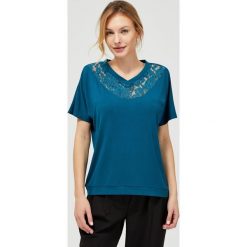 Bluzka z koronką przy dekolcie. Niebieskie bluzki damskie Moodo, xl, w koronkowe wzory, z elastanu, z dekoltem w serek, z krótkim rękawem. Za 9,99 zł.