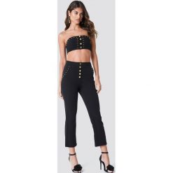 Galore x NA-KD Spodnie ze złotymi detalami - Black. Czarne spodnie damskie marki Galore x NA-KD. W wyprzedaży za 81,18 zł.