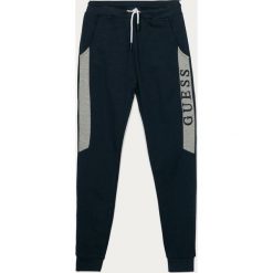 Guess Jeans - Spodnie dziecięce 116-175. Czerwone dresy chłopięce Guess Jeans, z aplikacjami, z bawełny. Za 159,90 zł.