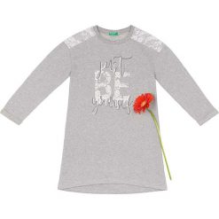 Sukienka w kolorze szaro-białym. Szare sukienki niemowlęce Benetton Kids, z nadrukiem, z koronki, bez rękawów, midi. W wyprzedaży za 49,95 zł.