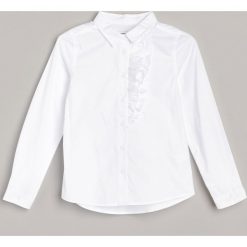Biała koszula z żabotem -. Białe koszule damskie Reserved, bez wzorów, bez kołnierzyka, bez rękawów. Za 59,99 zł.