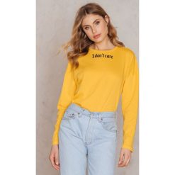 NA-KD Top I Don't Care - Yellow. Żółte topy damskie NA-KD, z napisami, z okrągłym kołnierzem. W wyprzedaży za 30,28 zł.