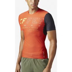 Reebok Koszulka Pomarańczowy. Pomarańczowe podkoszulki męskie Reebok, m, z nadrukiem, z elastanu, sportowe, bez kołnierzyka, krótkie. Za 343,95 zł.